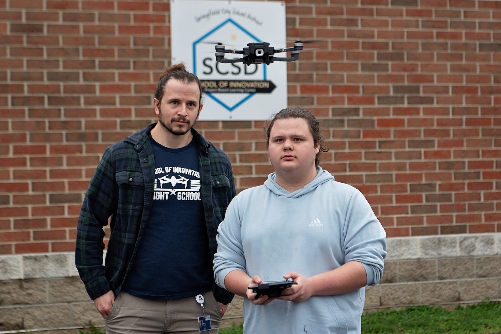 Leland Davis, a student at Springfield's School of Innovation, demonstrates his handling of a drone under the watch of his instructor,  Matt Perrine.