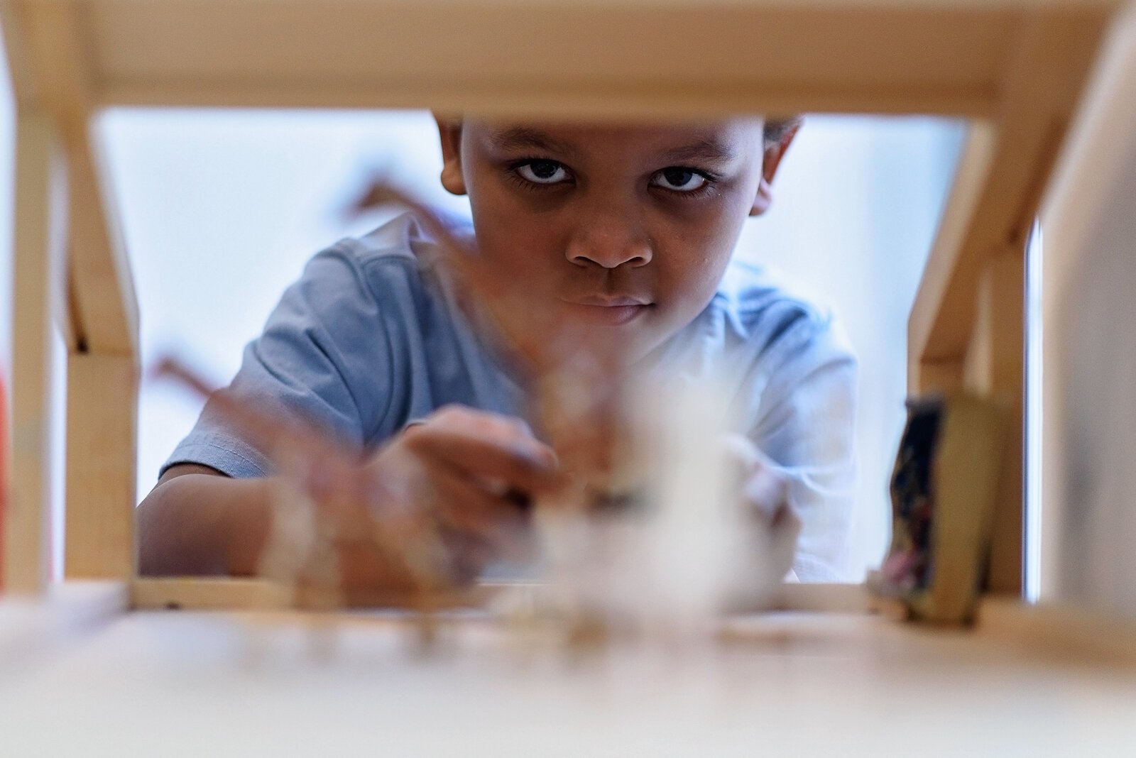 KahRelle Merchant looks through an opening of a toy house.