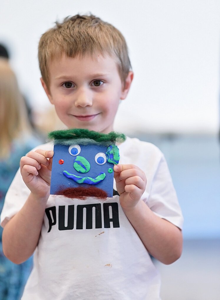 Skyler Strong shows off his dragon he made at the art museum.