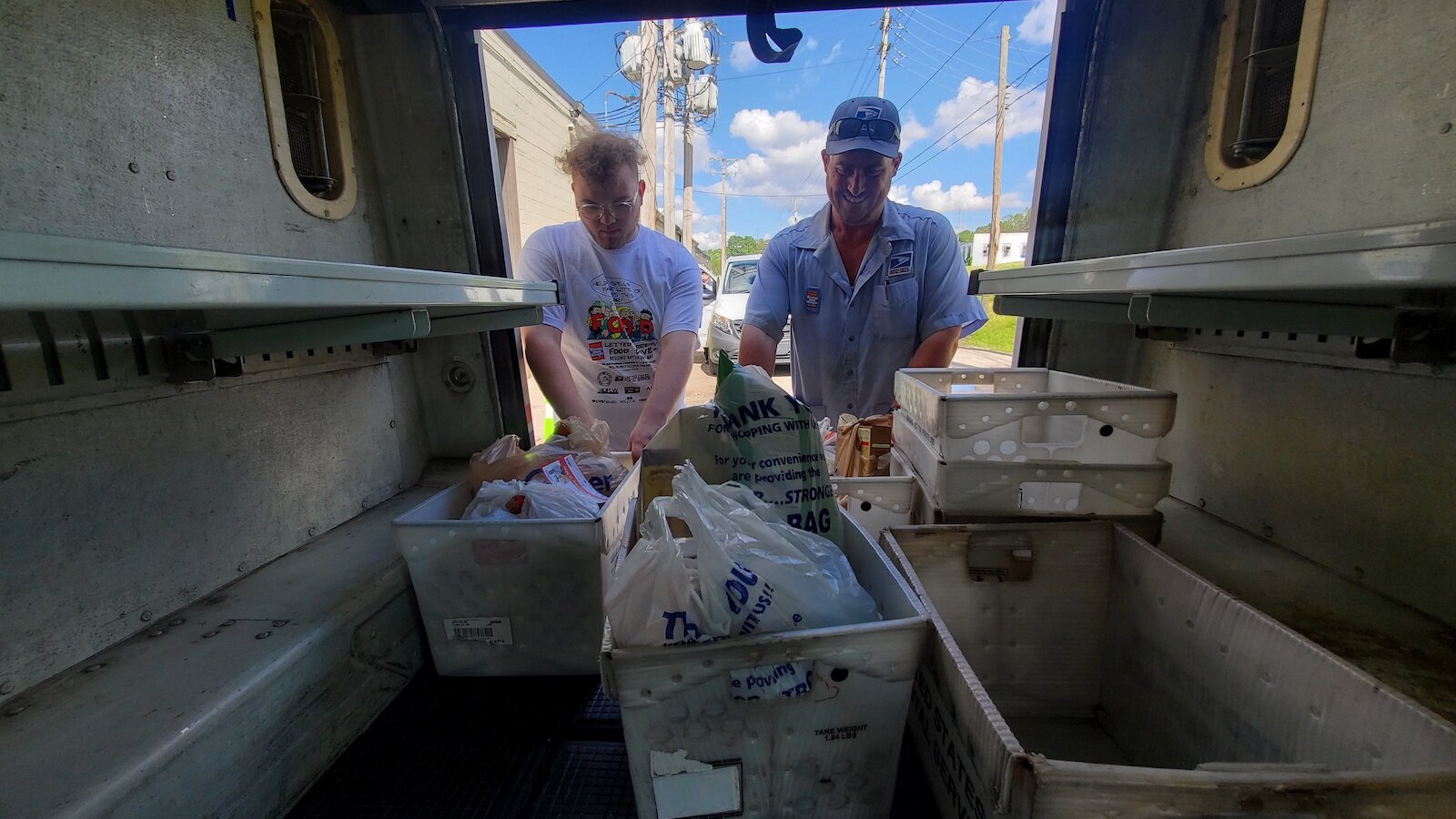 A letter carrier and volunteer unload donations during the 2024 Stamp Out Hunger Food Drive.