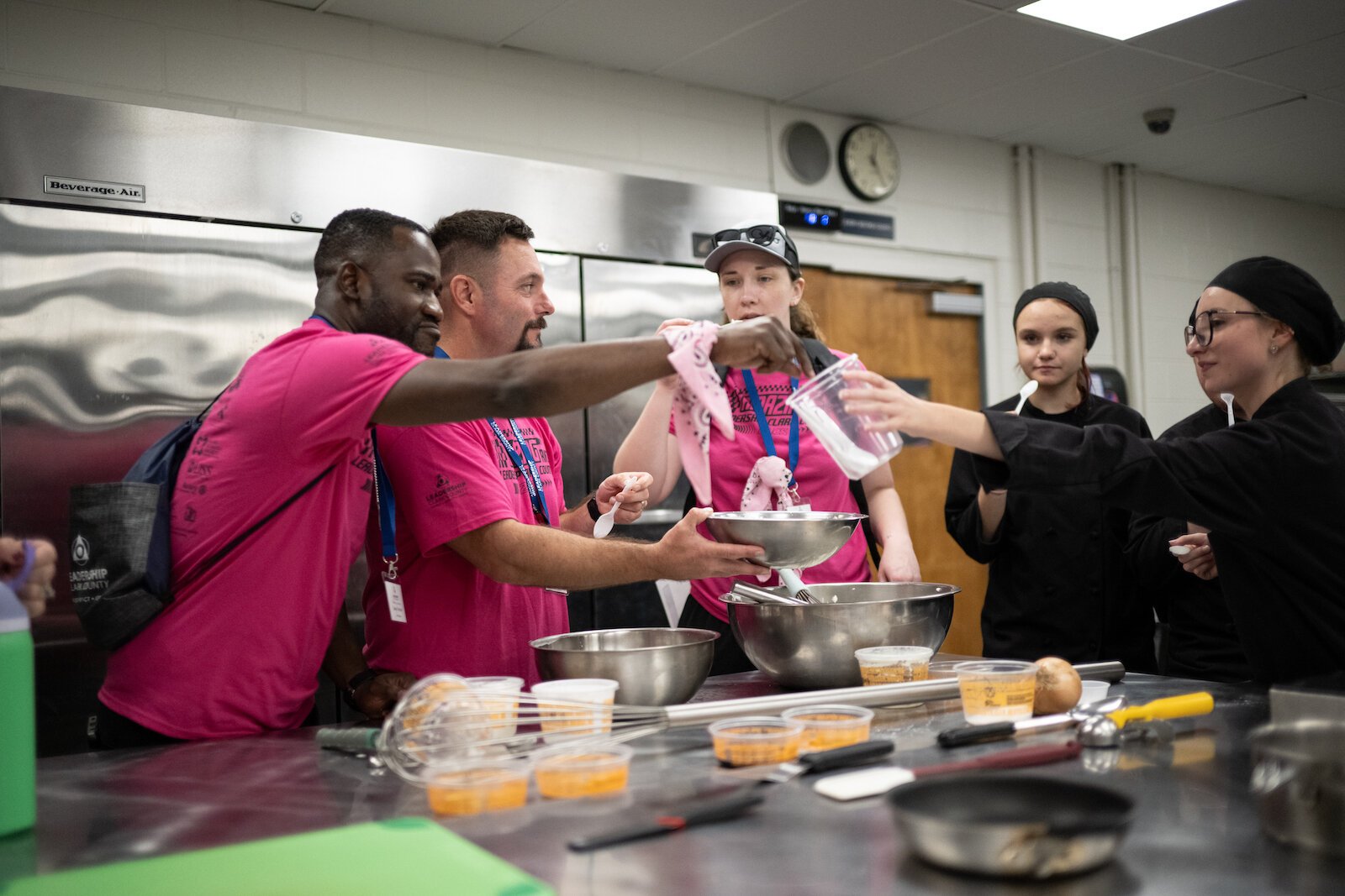 Community Leadership Academy participants work with Springfield-Clark CTC Culinary Arts students to make a sweet dessert topping.