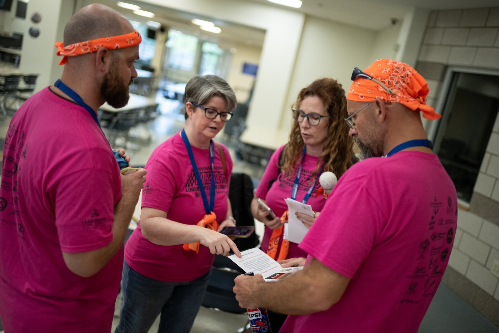 The orange team deciphers the clue to their next location on the Amazing Race.