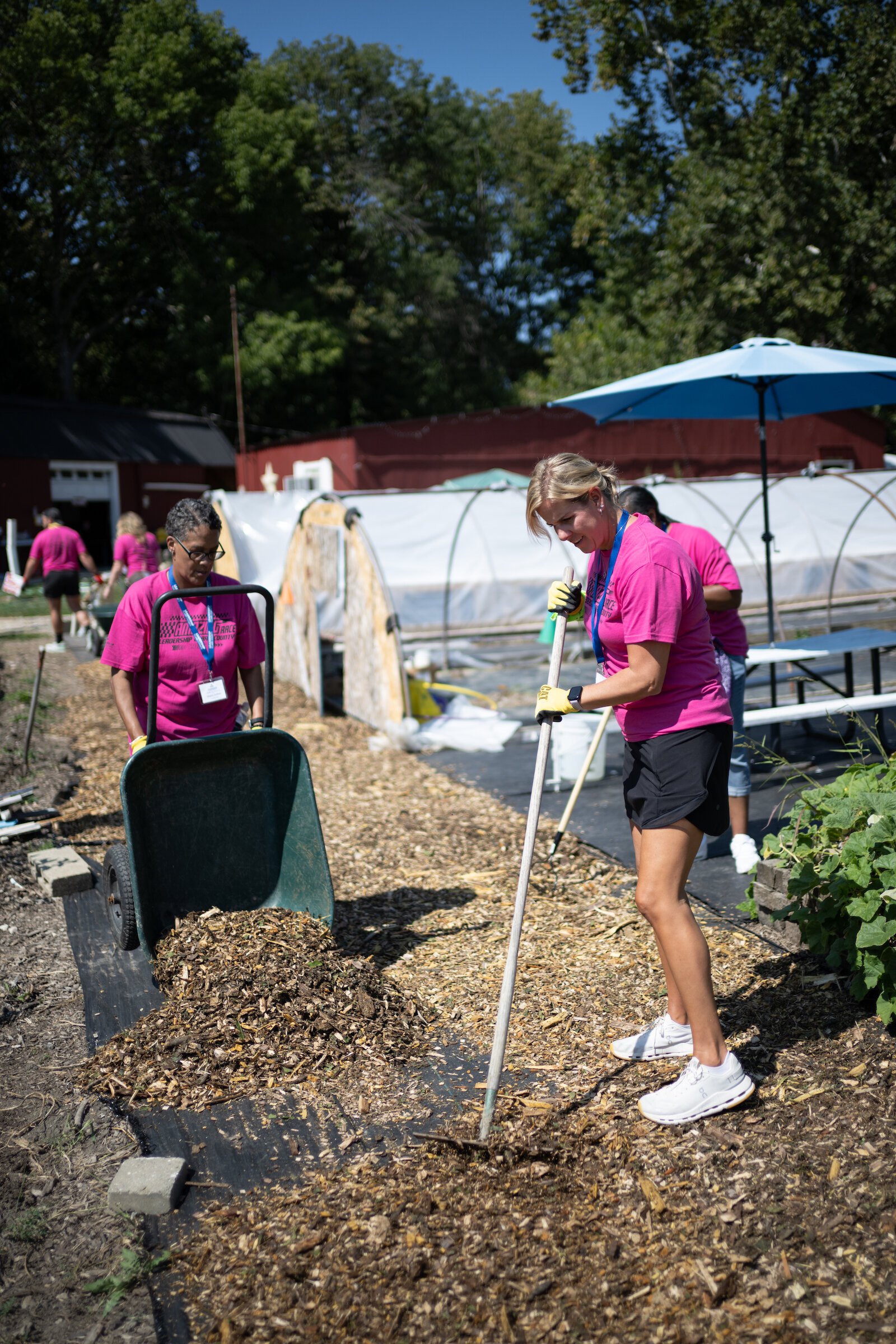 Community Leadership Academy participants add mulch around gardens and greenhouses.