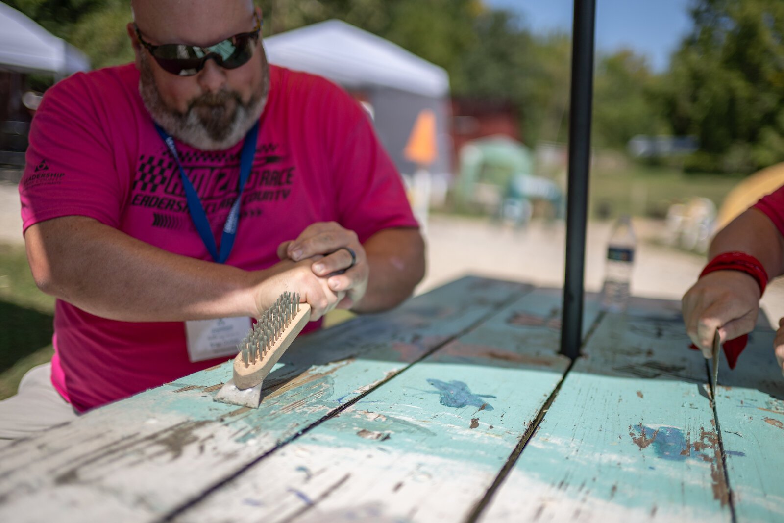 Participants strip old paint off of picnic tables.