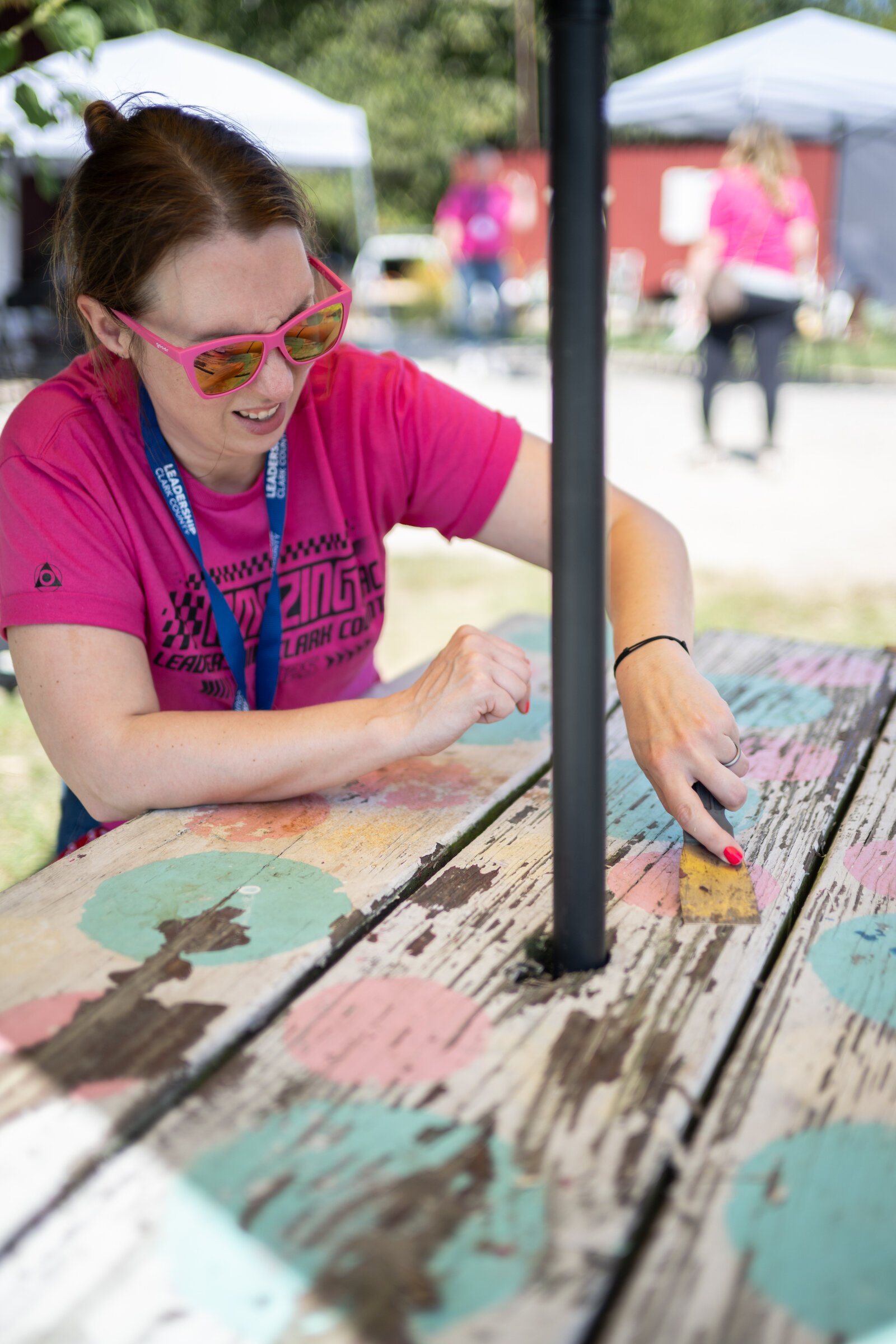 Participants strip old paint off of picnic tables.