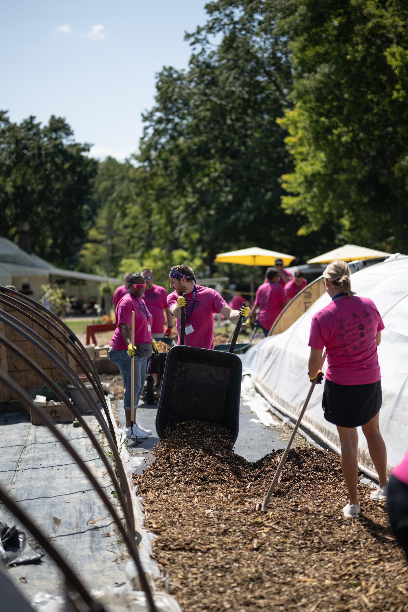 Community Leadership Academy participants add mulch around gardens and greenhouses.