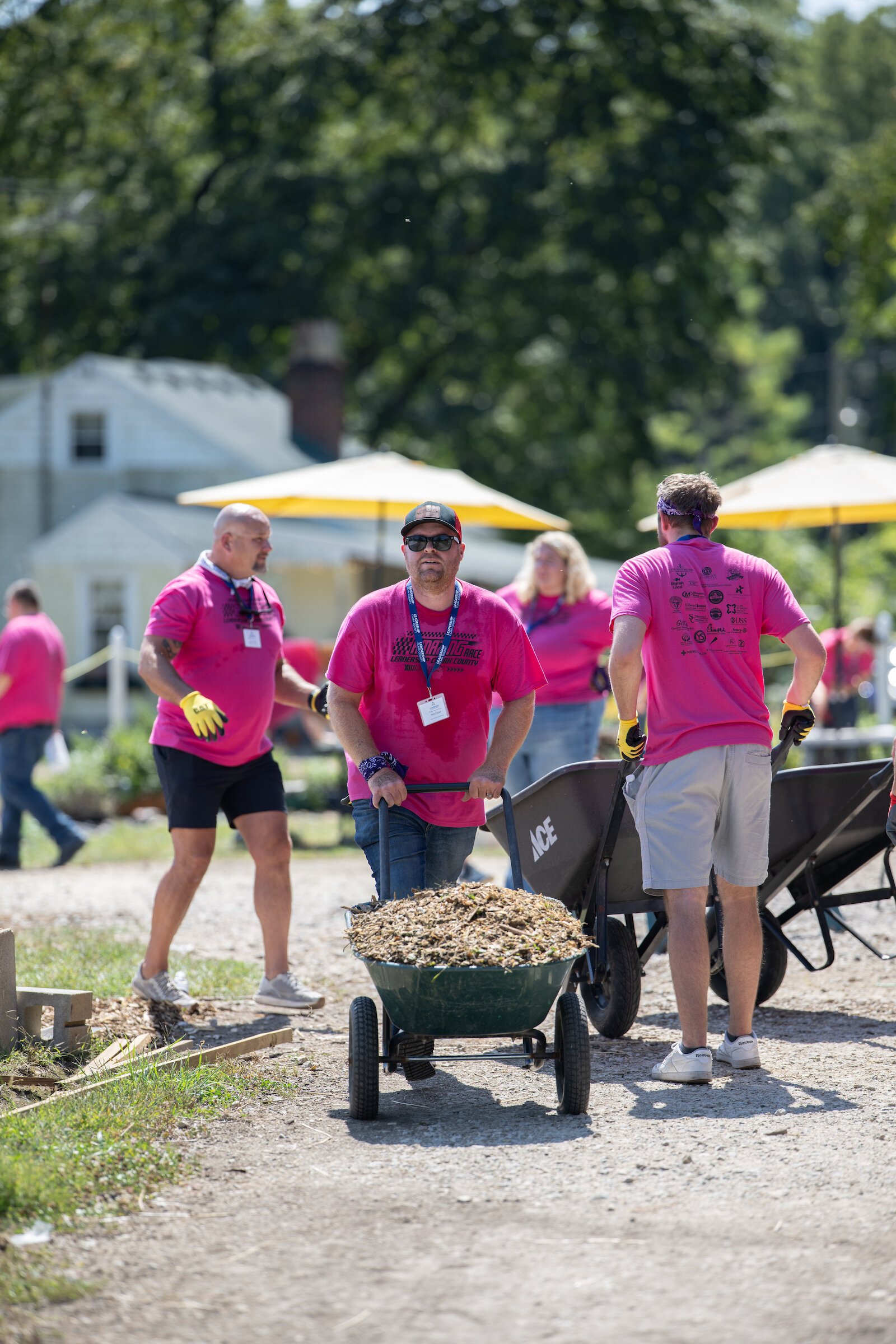 Community Leadership Academy participants add mulch around gardens and greenhouses.