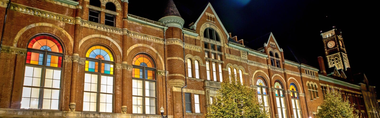 The Clark County Heritage Center is aglow at night, highlighting some of the stained glass arched windows.