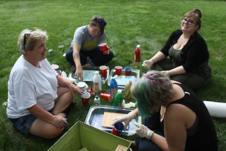 Angela Ward, left, gets hands on with people who visit her studio, including people with developmental disabilities.