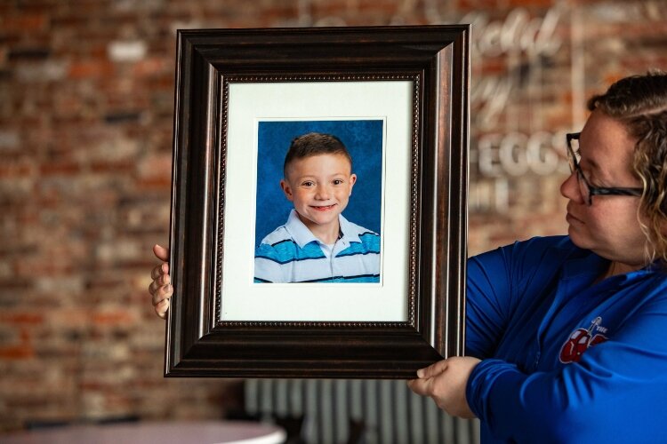 Lana Fitzsimmons holds a photo of her son Barrett, who died in 2019 from a form of childhood cancer. His family worked to build the Barrett Strong Foundation to raise money and make donations in his memory.