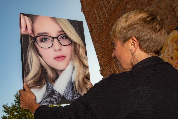 Dr. Lisa Delong looks at a portrait of her daughter Carly, who passed away three years ago after battling cancer. Delong is carrying on Carly's dream of developing a nonprofit.