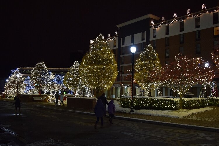 The esplanade between COhatch and The Courtyard by Marriott is covered in white lights.