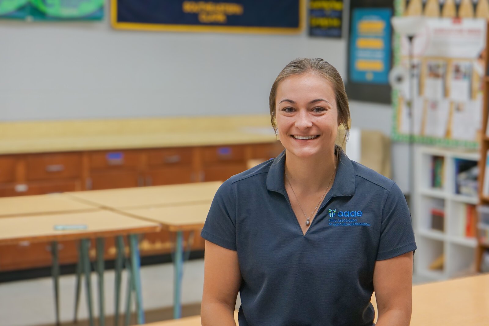 Ellyse Simpson sits in her classroom, wearing her Ohio Association of Agriculture Educators polo.
