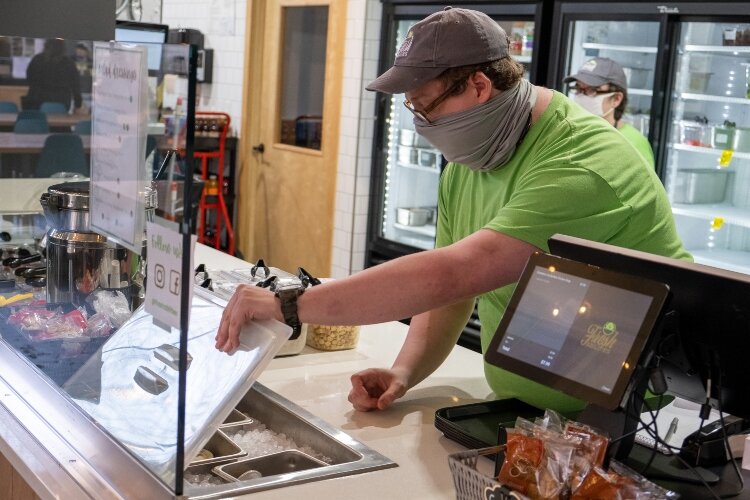 Travis Matthews checks the supply of salad and wrap ingredients at Fresh Abilities.