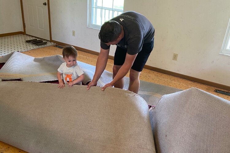 Zach Ayres and one of his children tear up carpet in a new home the family closed on, on June 2 in Clark County.