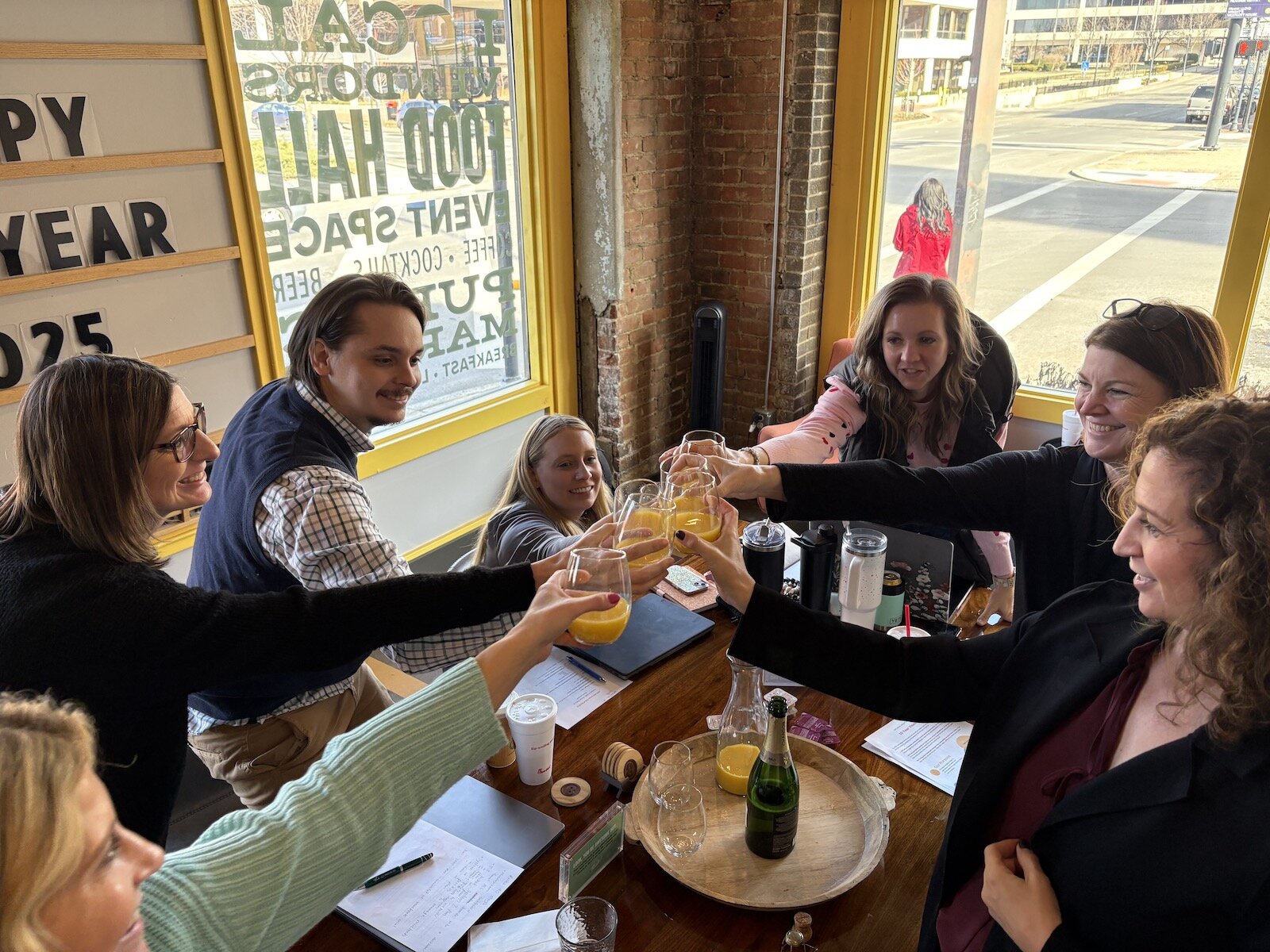 The Shift-ology team celebrates with a toast at a team meeting.