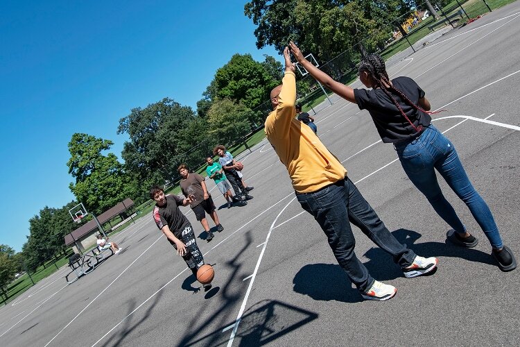 Chris Wallace, president of the Springfield chapter of My Brother's Keeper, plays basketball with students at Davey Moore Park.