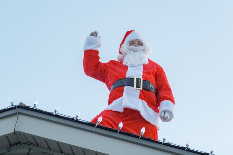 Rooftop Ramar Santa, Kevin Elliott, waves to families passing by in cars in Friday, Saturday, and Sunday nights in Ramar Estates.