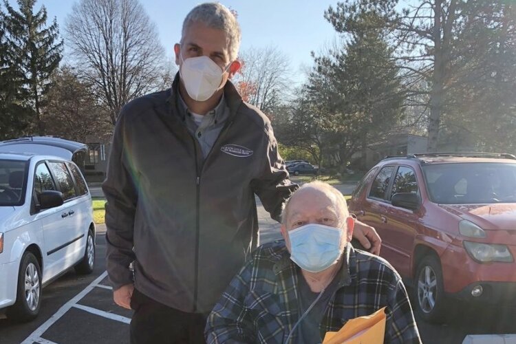 Frank Lewis (left), organizer of the local non-profit the Senior Dream Center, helps people like local resident Joe, who was supplied with a motorized scooter to help him gain freedom of mobility.