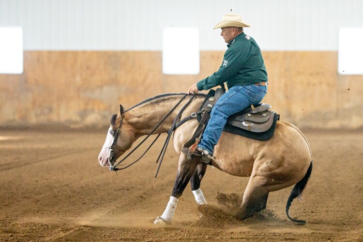 Shawn Flarida and Yellowstone perform a sliding stop, one of the maneuvers required in a reining pattern.