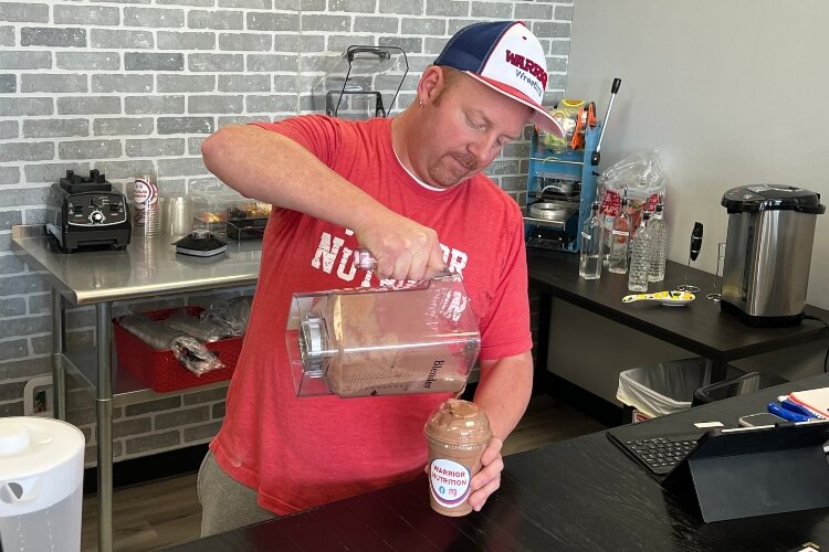 James Chapman, who co-owns Warrior Nutrition with his wife Danielle, makes one of the new shop's popular protein shakes.