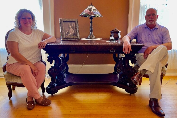 Kim and Ed Buchwalter sit with some of the historic furniture they donated to the Woman's Town Club to help the group restore the historic home.