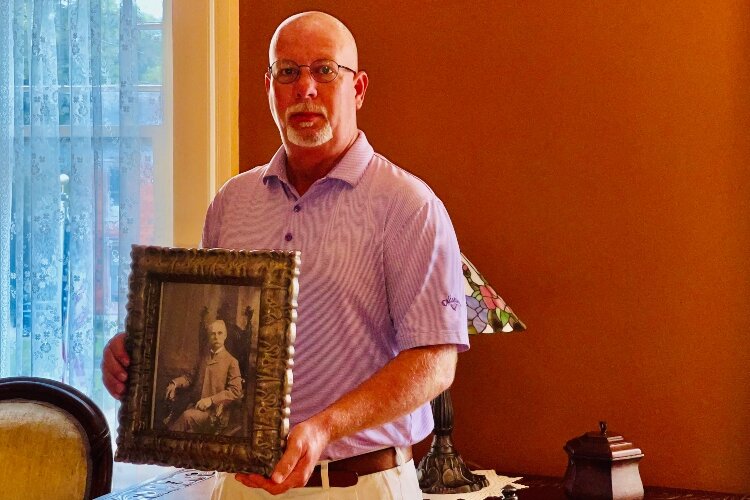 Ed Buchwalter holds a photo of his uncle, Capt. Ed Buchwalter, who formerly owned the historic home of what is now the Woman's Town Club.